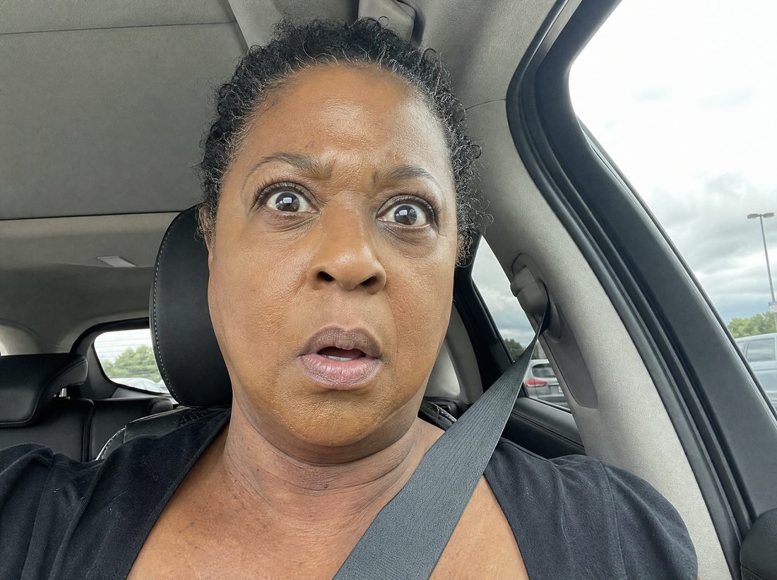 A woman in her car catching sight of her foundation in daylight